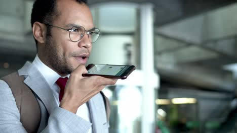 Young-businessman-talking-by-smartphone